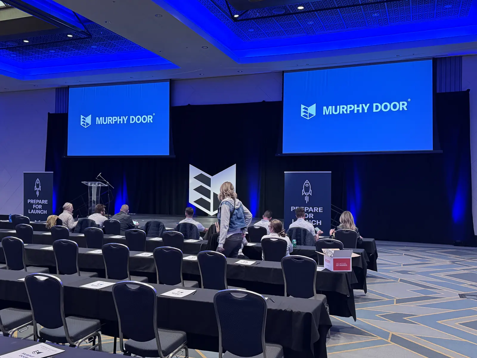 A Murphy Door® corporate event stage with the wordmark on both screens. Company photo.